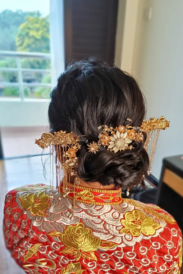 Low bridal bun with gold phoenix hairpins for a Qun Kua, hairstyling by THEENG in Kuantan