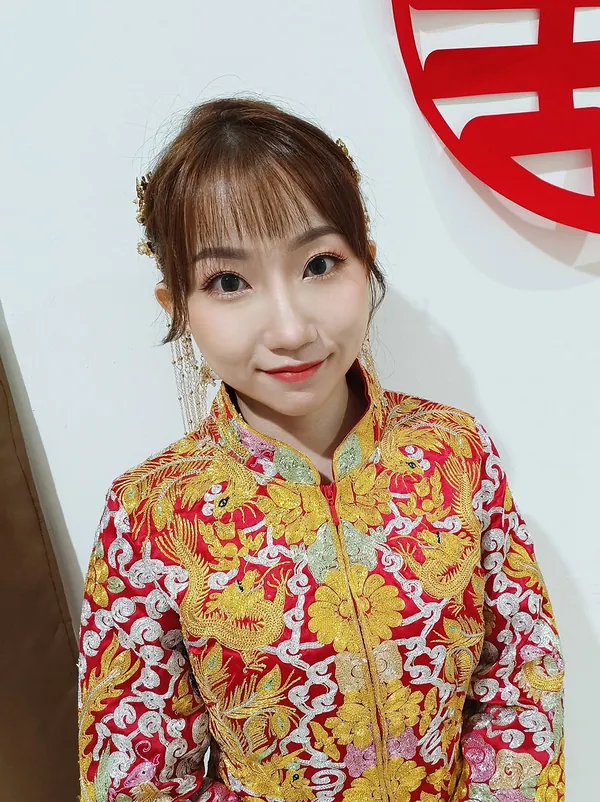 Qun Kua bride with side-swept fringe and gold hair ornaments, makeup by THEENG in Kuantan