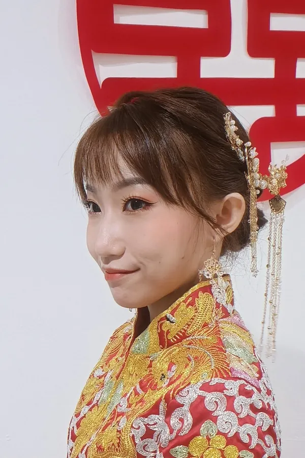Qun Kua bride smiling in profile with gold tassel hairpin, makeup by THEENG in Kuantan