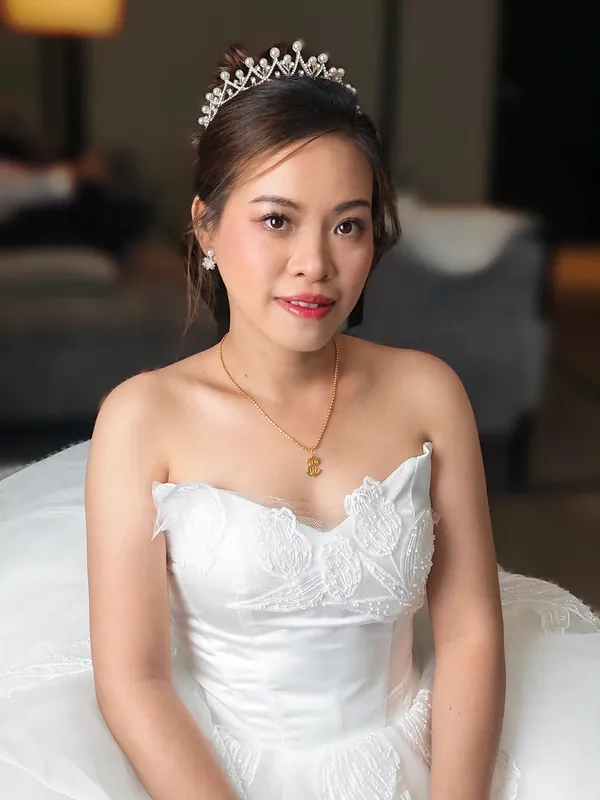 Bride in strapless white gown with pearl tiara, soft bridal makeup by THEENG in Kuantan