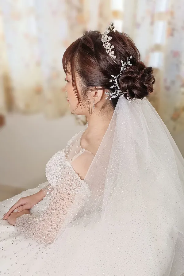 Bride with veil and pearl hair vine on a low bun, makeup and veil styling by THEENG, Kuantan