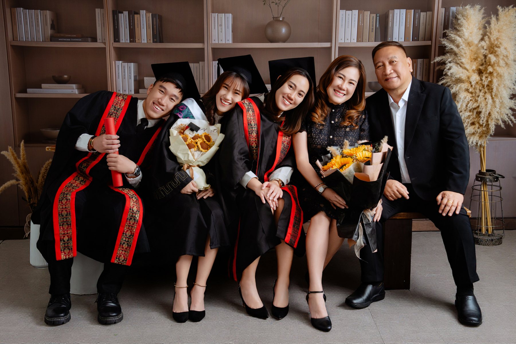Graduate family portrait on warm studio backdrop