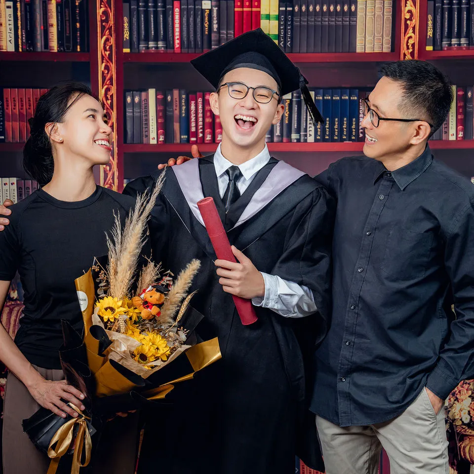 Graduate with parents and bouquet in Kuantan studio